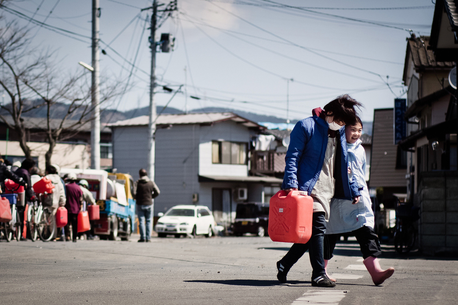 Photo of people in line to receive fuel in Japan.