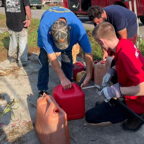 Photo of volunteers filling gas cans in fuel assistance program